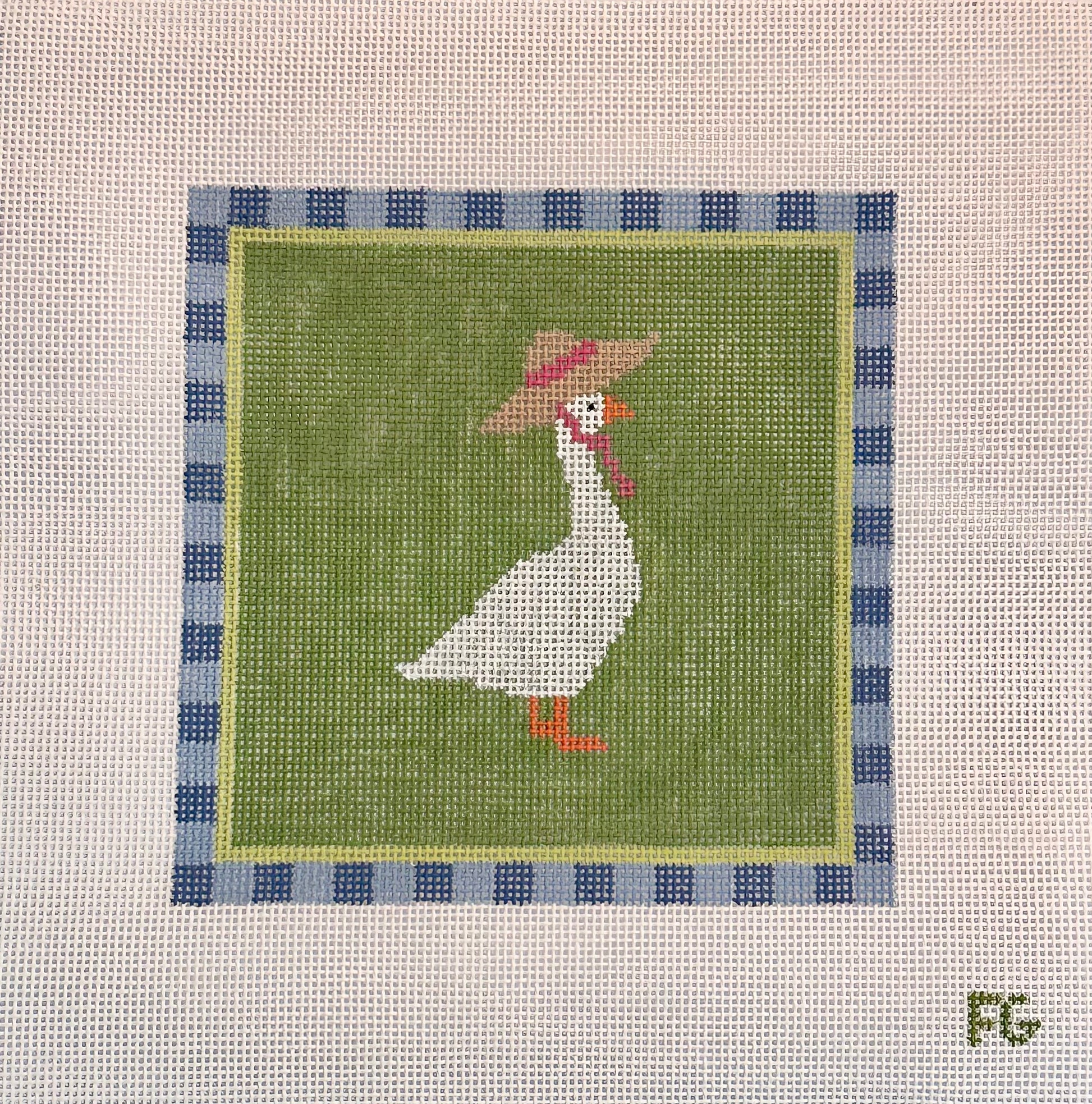 A square needlepoint canvas featuring a white goose wearing a brown hat with a pink band, set against an olive green background with a blue and white checkered border. The canvas is displayed flat against a white mesh background.