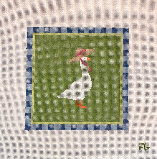 A square needlepoint canvas featuring a white goose wearing a brown hat with a pink band, set against an olive green background with a blue and white checkered border. The canvas is displayed flat against a white mesh background.