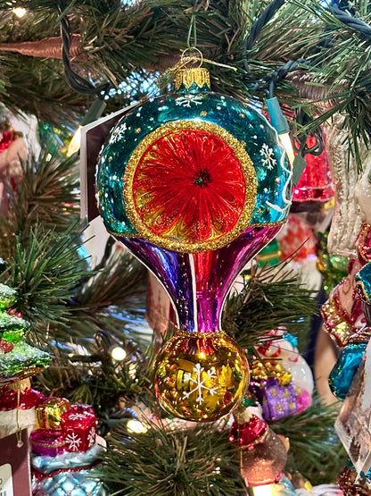 Decorative Christmas ornament on a tree with colorful glass design