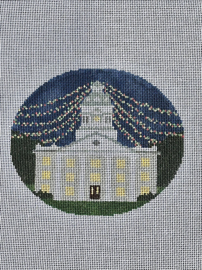 needlepoint canvas with white building and christmas lights 