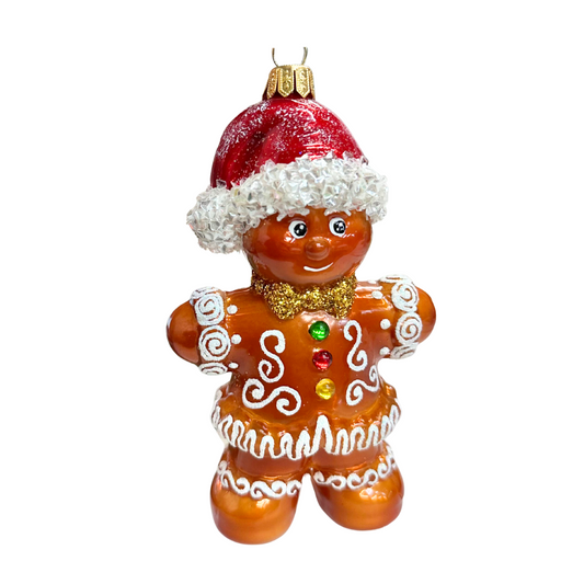 Decorative gingerbread man ornament with a red hat and white frosting on a white background
