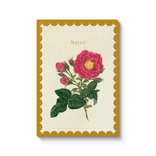 A vertical notebook with a cream-colored cover, featuring a vintage-style illustration of a pink rose with green leaves. The notebook has a scalloped mustard-yellow border and the word 'Notes' printed near the top.