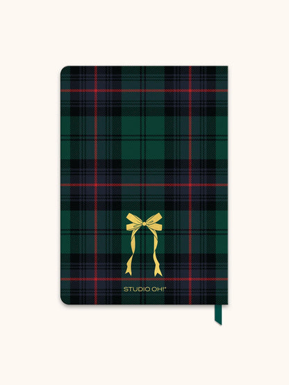 A Studio Oh! hardcover notebook featuring a dark green and black tartan plaid pattern with thin red and yellow stripes, a yellow ribbon graphic, and the brand name 'STUDIO OH!' printed in gold near the bottom.