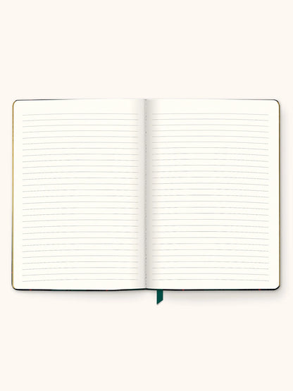 An open lined notebook with blank pages, shown from above on a plain light beige background. A small dark green ribbon bookmark is visible at the bottom center.