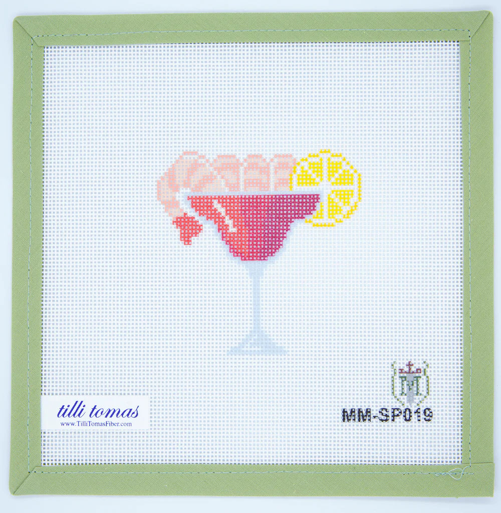 Cross-stitched design of a cocktail glass with a lemon wedge on fabric, framed by a green border.