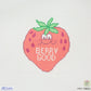 Cross-stitched strawberry with a face and 'Berry Good' text on a white background