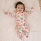 Baby wearing a colorful butterfly-patterned onesie on a striped blanket