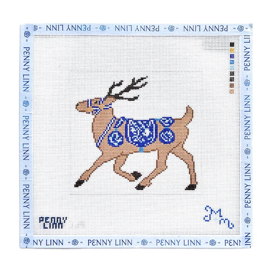 A Penny Linn needlepoint canvas featuring a brown reindeer with a blue patterned saddle and bridle, on a white grid background with a blue border printed with the brand name.