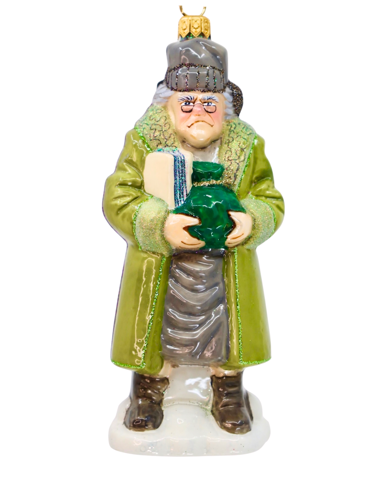 A hand-painted glass ornament depicting Ebenezer Scrooge in a green coat, gray hat, and holding a green potion bottle, set against a plain white background.