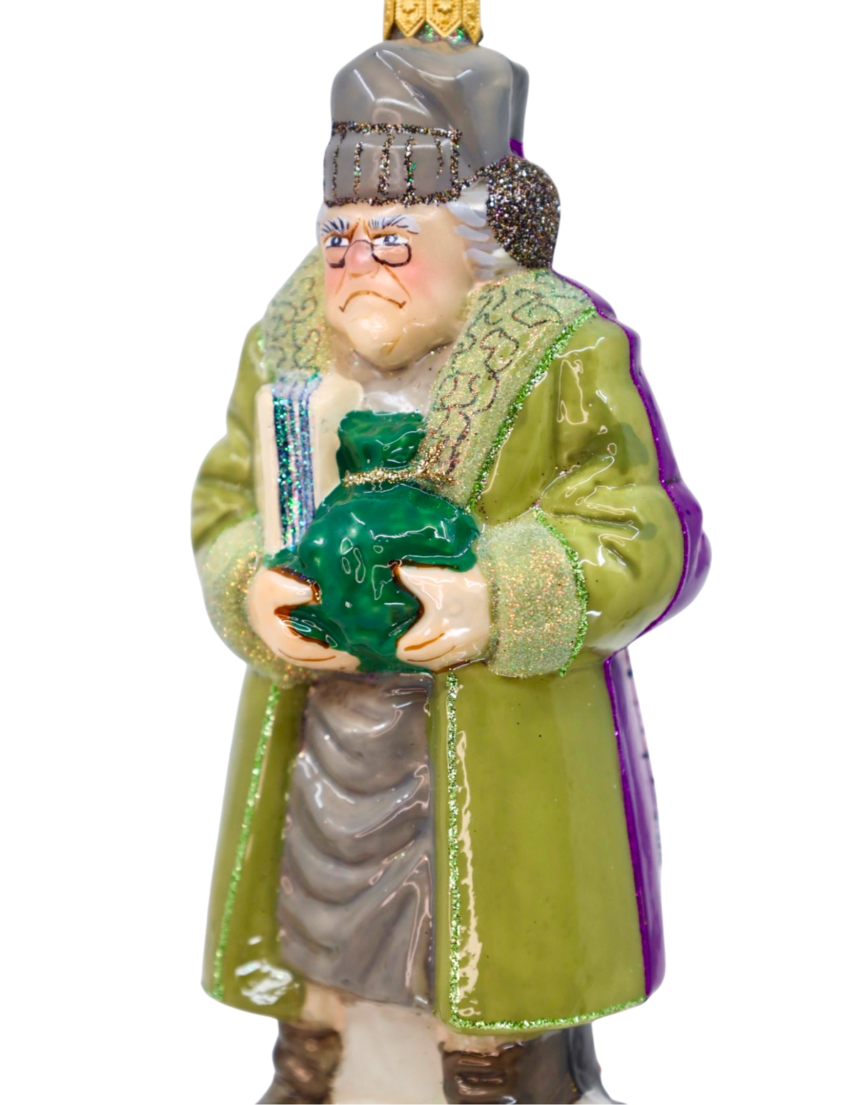 A vintage-style ornament depicting an elderly man in a green coat holding a green satchel, with a gray hat and gold top, isolated on a white background.