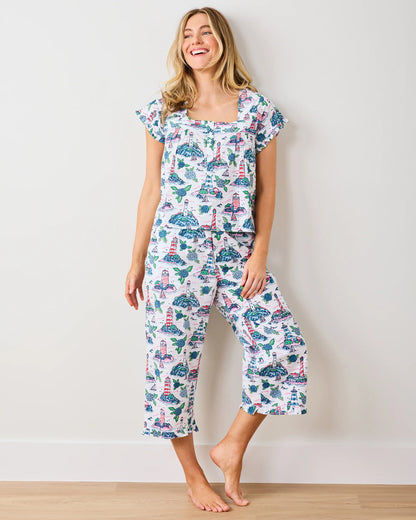 Woman wearing a patterned pajama set with a white background