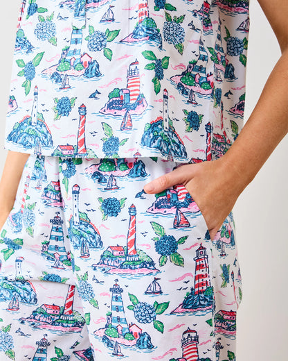 Patterned shirt with lighthouse and floral design on a white background