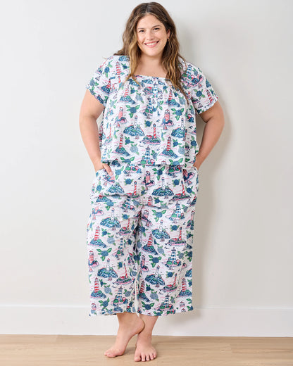 Woman wearing a patterned pajama set against a plain background
