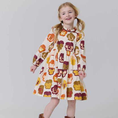Young girl wearing a floral dress against a plain background