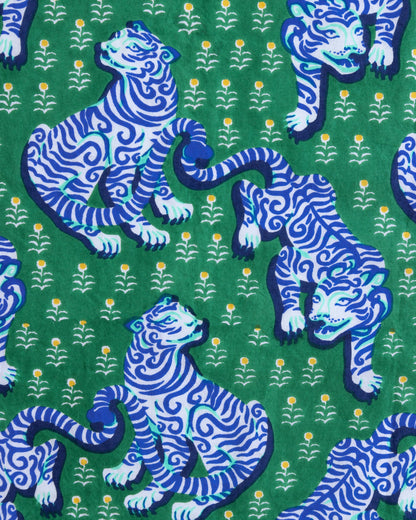 Pattern of blue tigers on a green background with small yellow flowers.