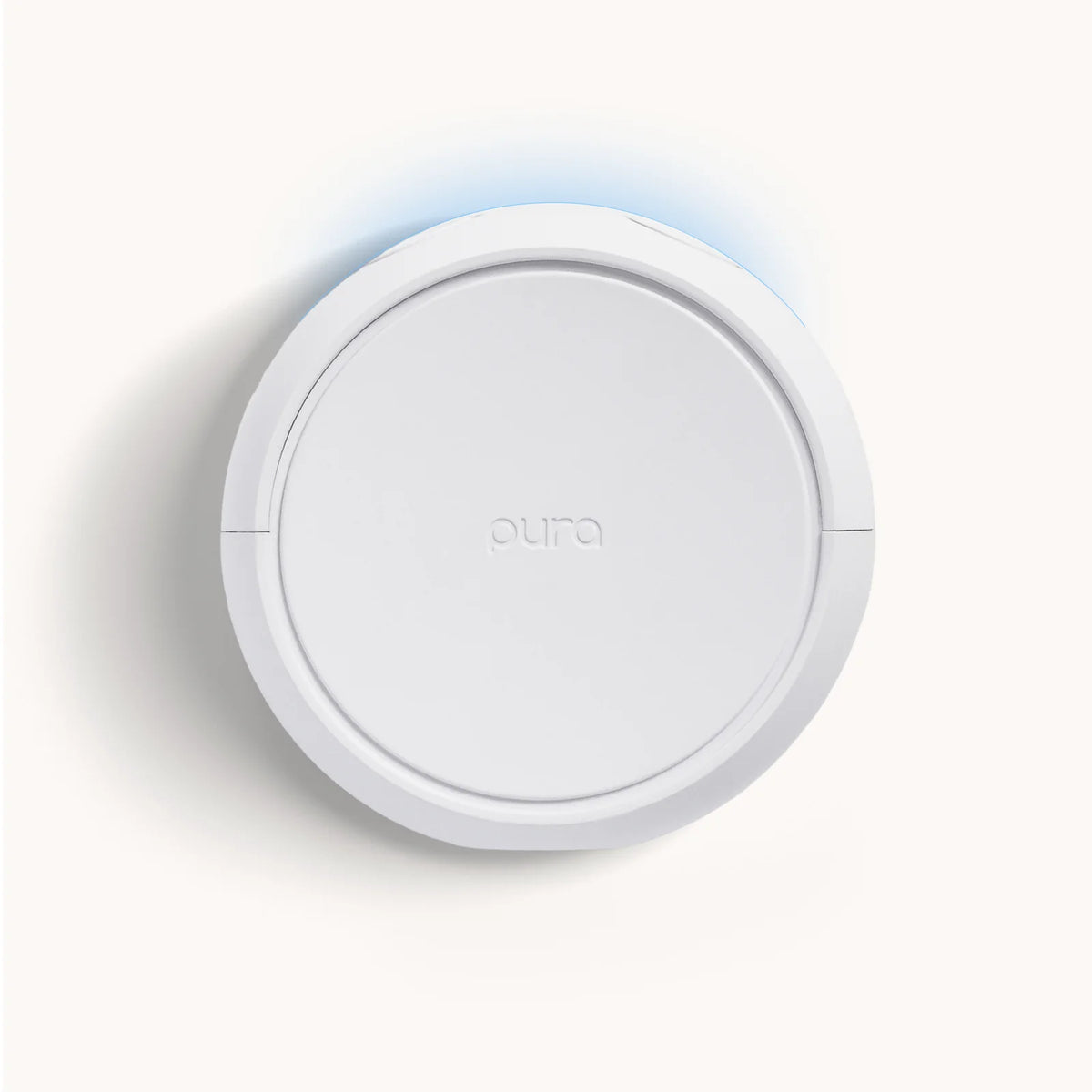 Round white device with 'aura' branding on a light gray background