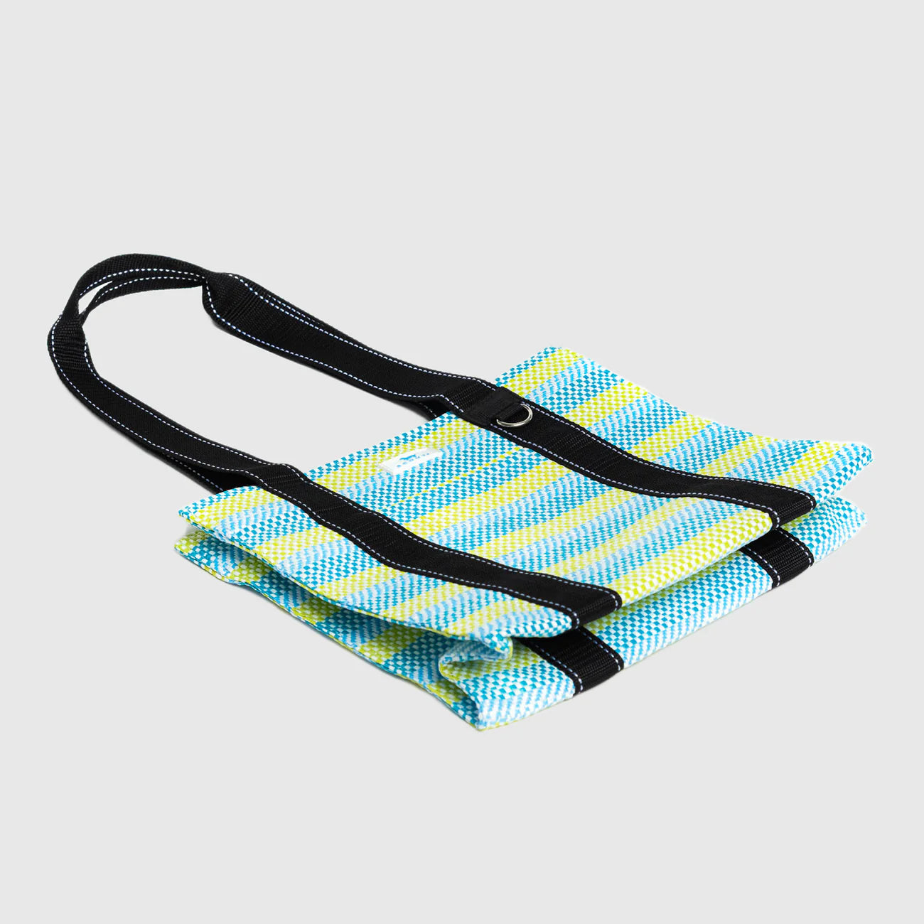 Foldable blue and yellow striped mat with a black strap on a light gray background