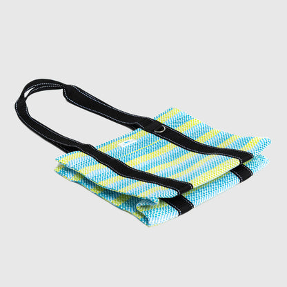 Foldable blue and yellow striped mat with a black strap on a light gray background