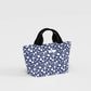 Blue floral-patterned tote bag with black handles on a light gray background