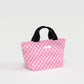 Pink checkered bag with black handles on a light gray background