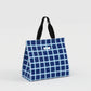 Blue checkered tote bag with black handles on a light gray background