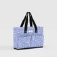 Purple floral-patterned tote bag with black handles on a light gray background