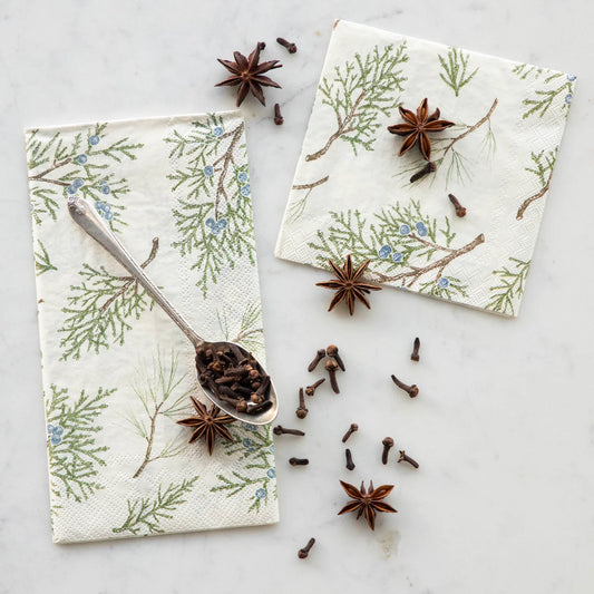 Napkins with floral and branch pattern on a marble surface with star anise.