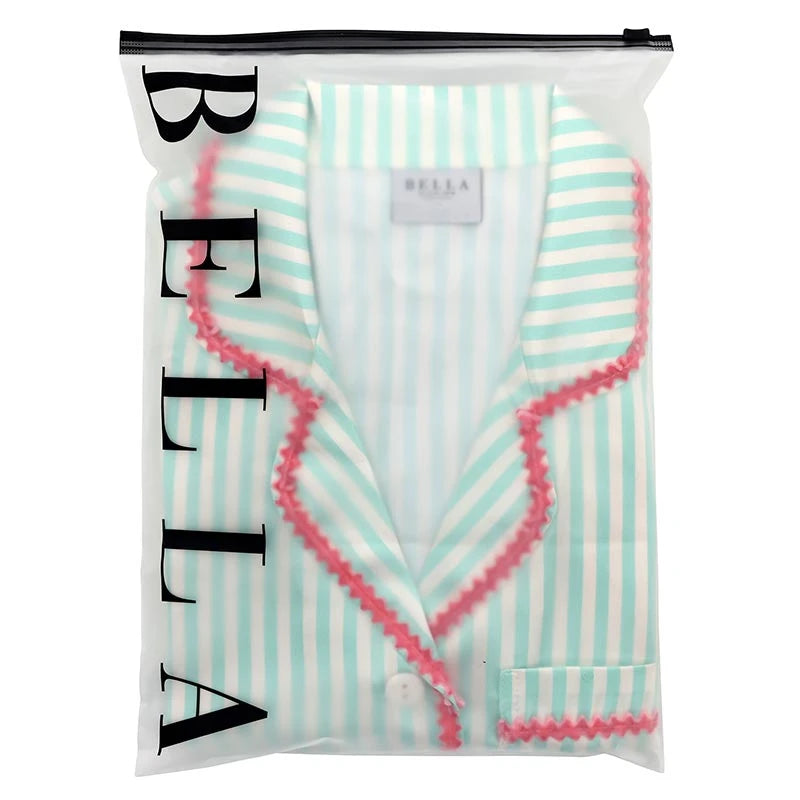 A mint green and white striped pajama shirt with pink ruffled trim, folded and sealed inside a clear plastic bag with the brand name BELLA printed vertically on the side.