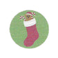 Circular green patch with a cartoonish sock character wearing a Santa hat on a white background