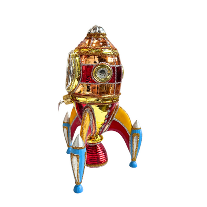 Decorative rocket-shaped ornament with gold, red, and blue colors on a white background