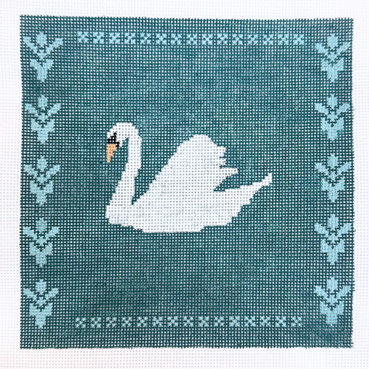 A square needlepoint canvas featuring a white swan with a yellow beak on a teal background, framed by a border of light blue floral motifs and white geometric patterns.