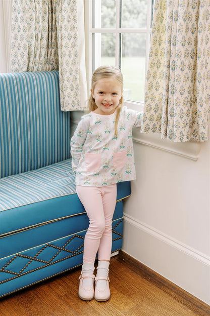 Young girl in a room with floral curtains and a blue couch