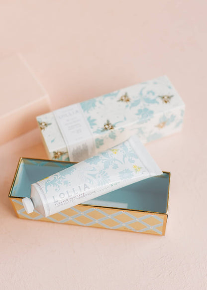 Hand cream tube with floral packaging on a pink background