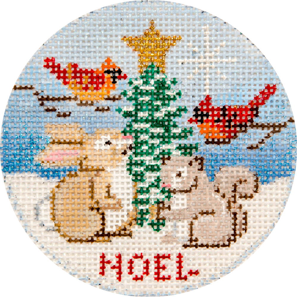 Round cross-stitch design with Christmas scene featuring animals around a tree with 'HOEL' text.