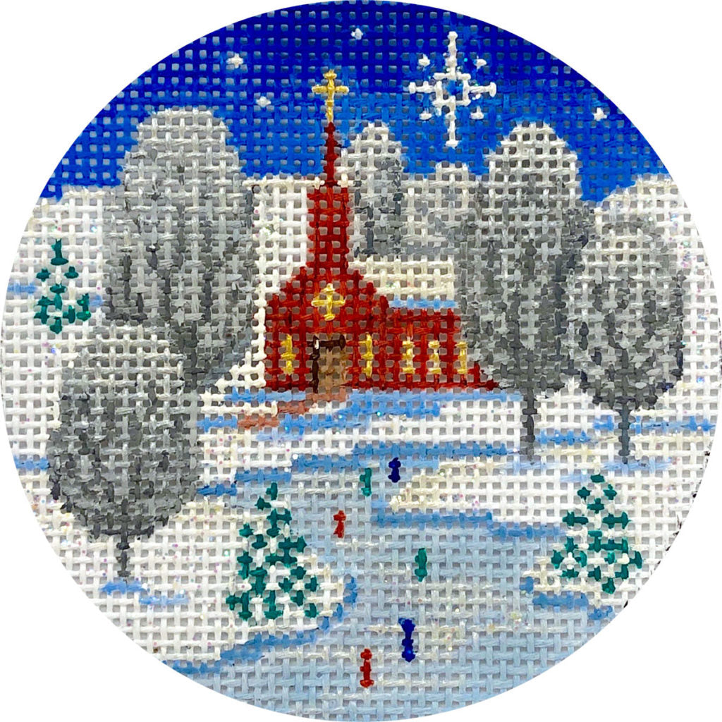 Circular needlepoint ornament with a winter scene featuring a church and people skating.