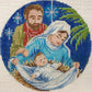 Decorative needlepoint of the nativity scene with Mary, Joseph, and baby Jesus.