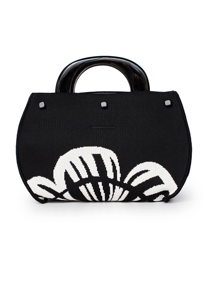 Black handbag with a white floral design on a white background