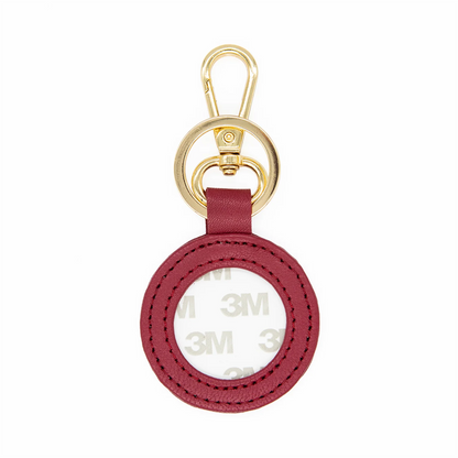 Red circular keychain with gold clasp on a white background