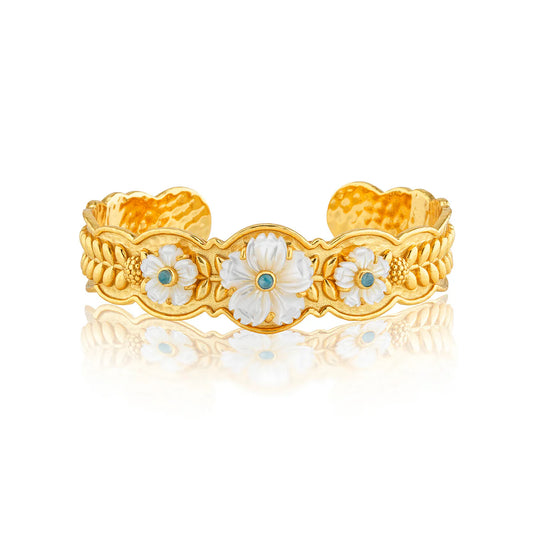 Gold bracelet with floral designs on a white background