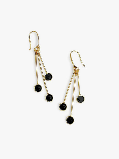 Gold earrings with black beads on a white background