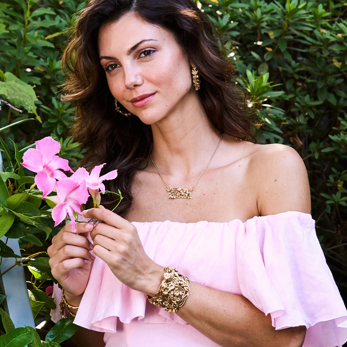 Woman holding pink flowers in a garden setting