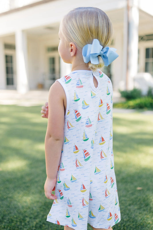 Child wearing a dress with sailboat pattern outdoors