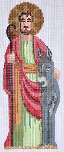 A needlepoint canvas design featuring Jesus with a brown halo, holding a staff, wearing a red cloak over a green tunic, standing next to a gray donkey on a white grid background.