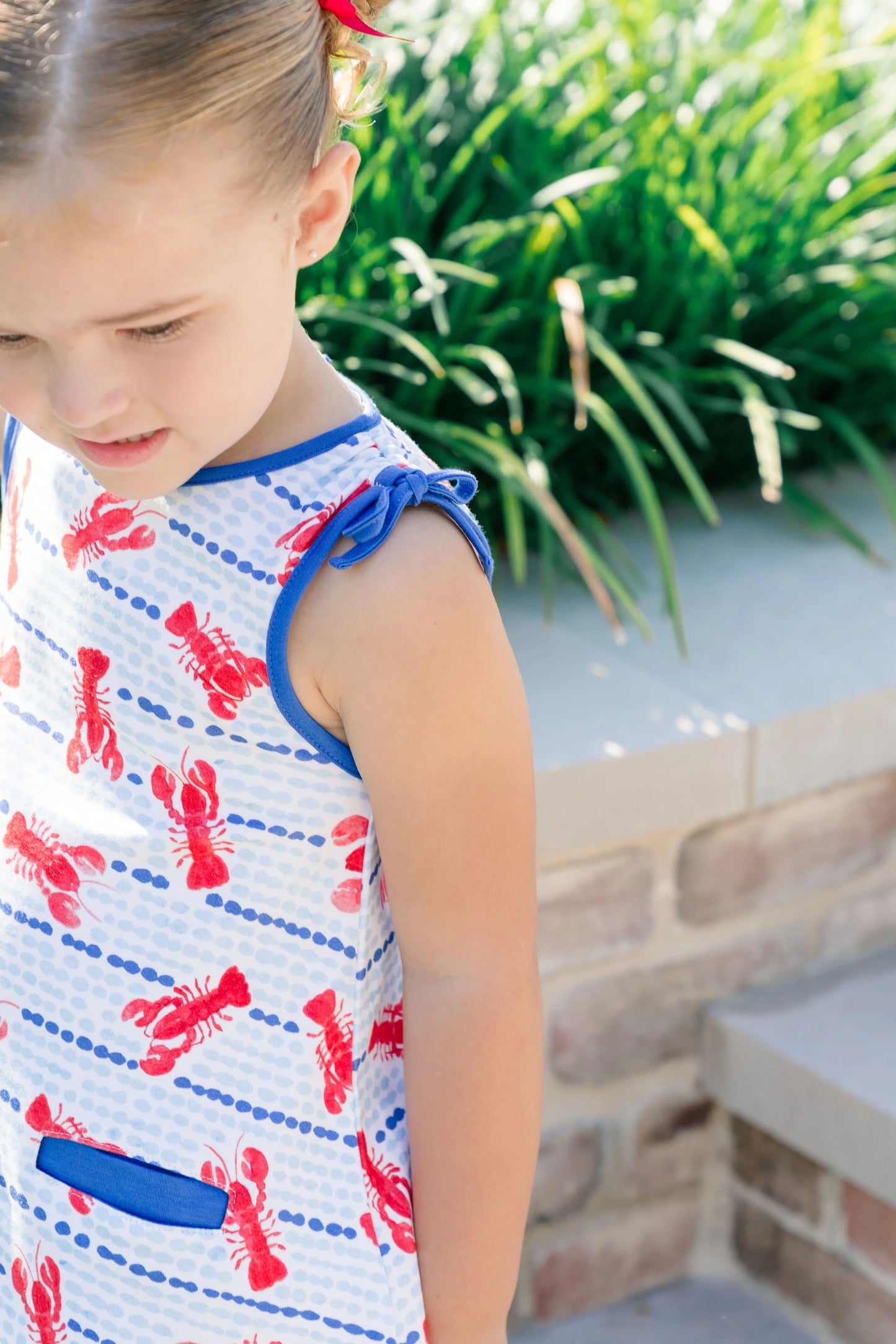 Young girl wearing a dress with lobster print outdoors