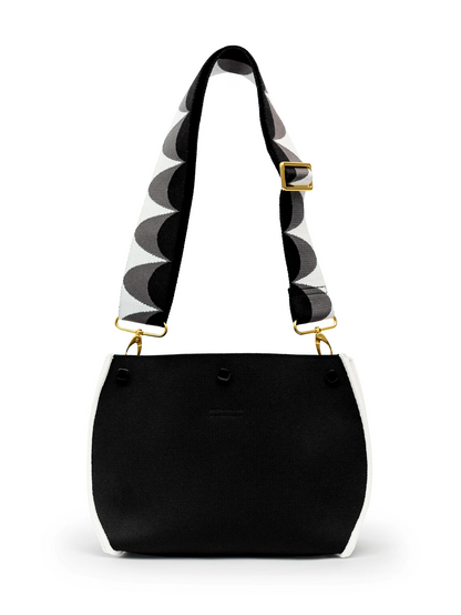 Black handbag with a patterned strap on a white background