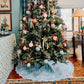 Decorated Christmas tree with ornaments in a living room setting.