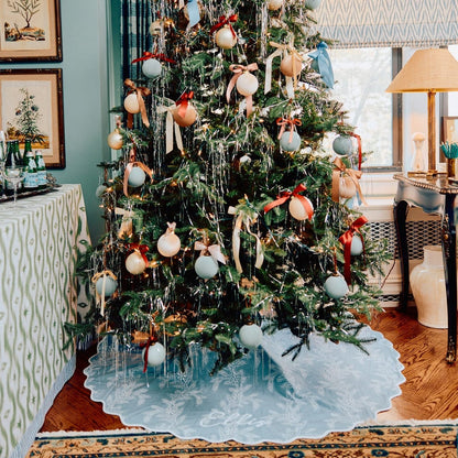 Decorated Christmas tree with ornaments in a living room setting.
