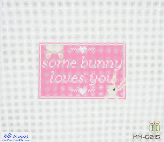Cross-stitched pattern with 'some bunny loves you' text on a pink background