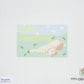 Cross-stitch pattern of a baby seal sleeping with 'Baby Sleeping' text on a light blue background.