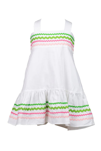A white Sundress with multicolored ric rac trim and a bow at the back neck, designed for children.